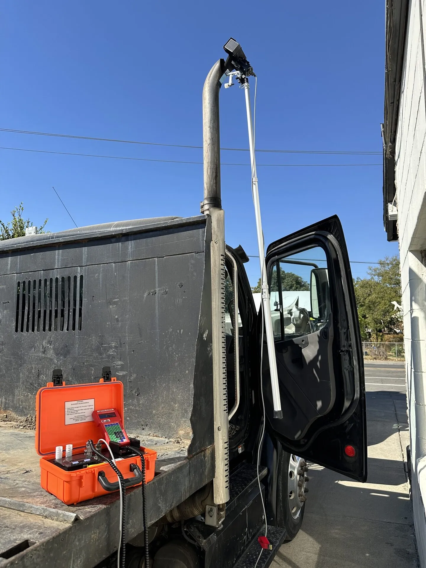 OVI smoke opacity probe attached to a diesel truck exhaust stack with test equipment on the truck bed